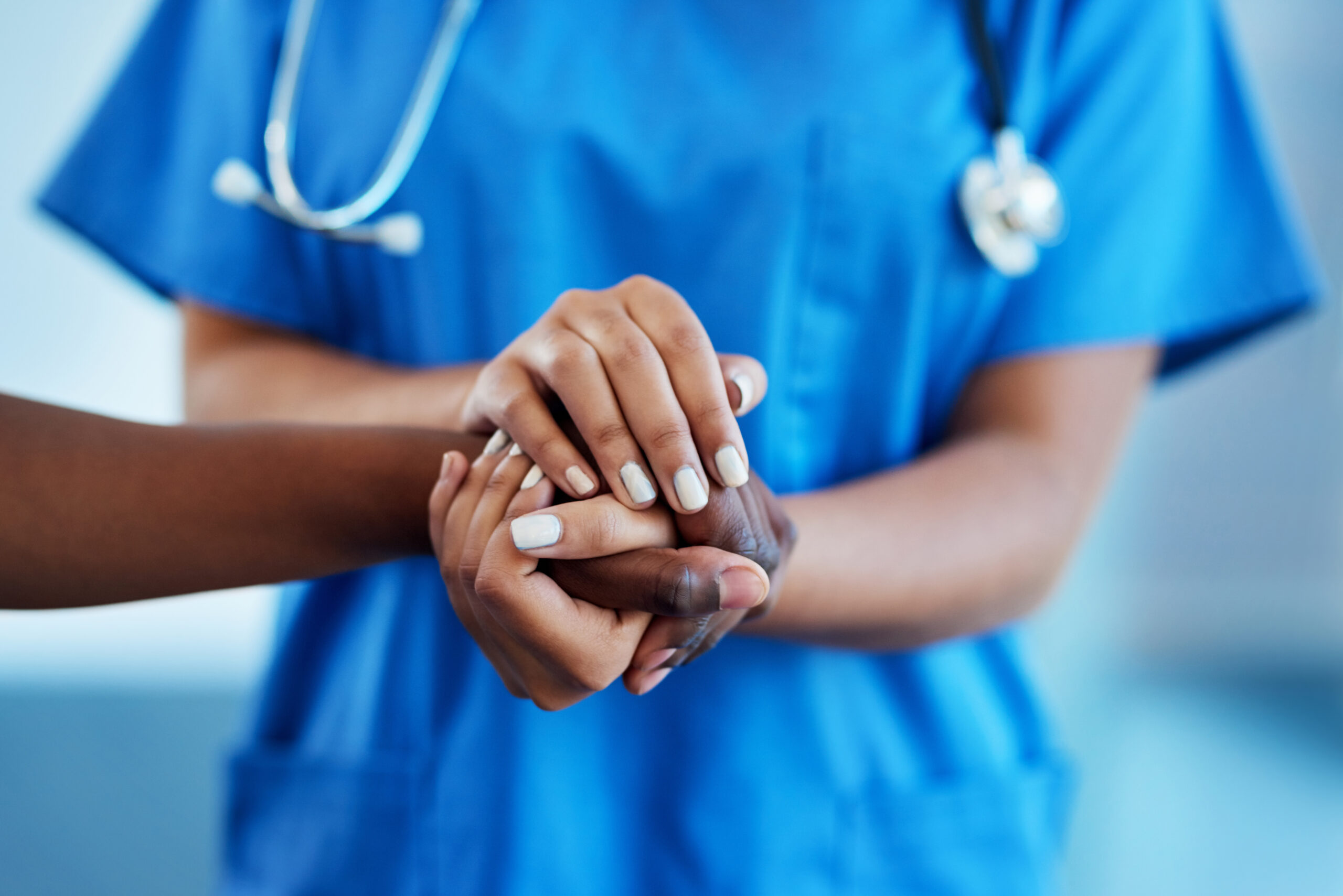 Closeup shot of a nurse holding a patient's hand in comfort